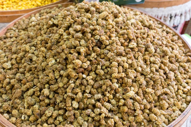 A wide bowl heaped with pale golden dried white mulberries